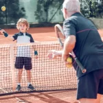 Tennis player teaching kid
